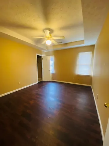 a view of a big room with wooden floor and windows