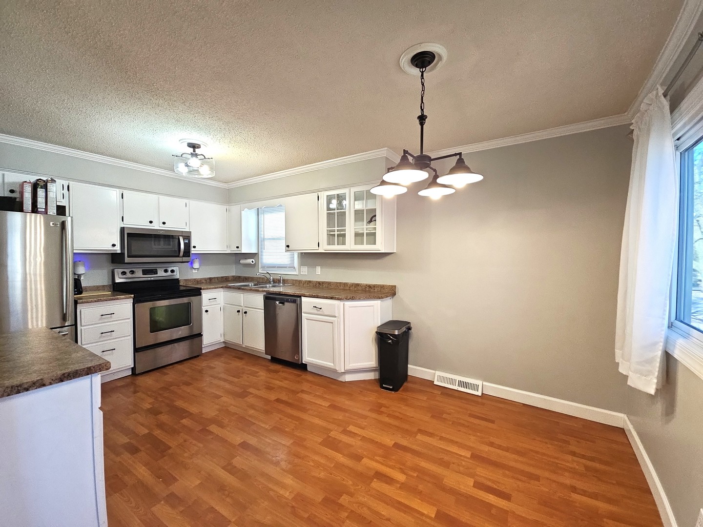 1322 Calvin Street Davenport, IA 52804 - Photo 5 of 25 a kitchen with stainless steel appliances granite countertop a refrigerator a sink dishwasher a stove and white cabinets with wooden floor