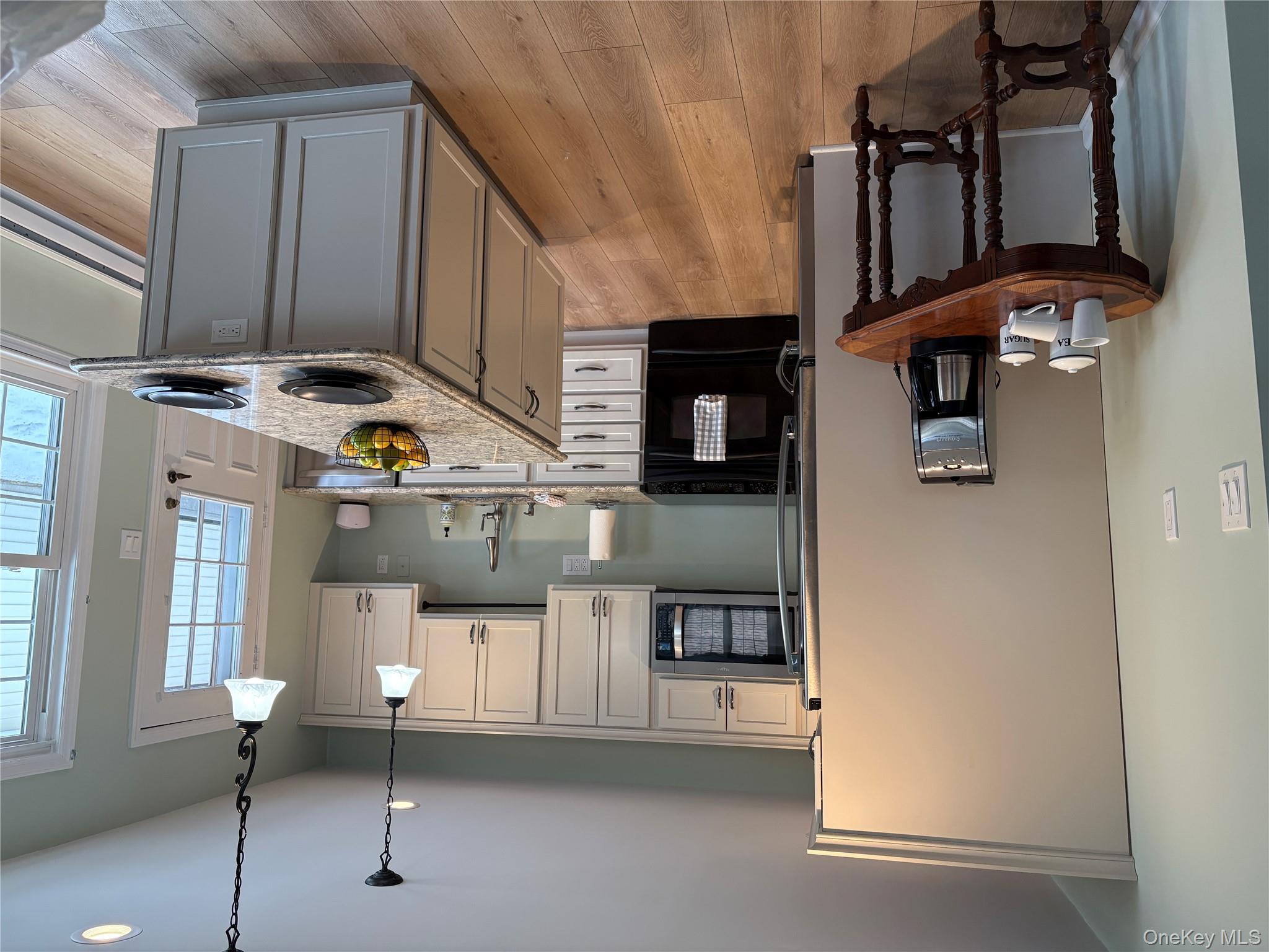498 Cranston Lane Ridge, NY 11961 - Photo 7 of 30 Kitchen with stainless steel appliances, pendant lighting, Quartz counters, kitchen island with cabinets on either side and pull out mixer shelf.