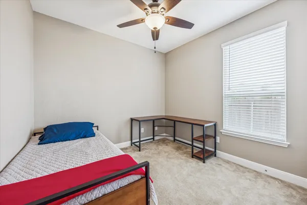 a bedroom with a bed a window and a chandelier