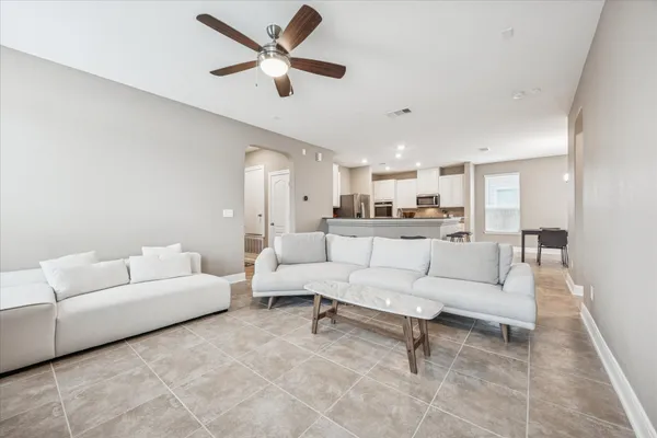 a living room with furniture and a view of kitchen