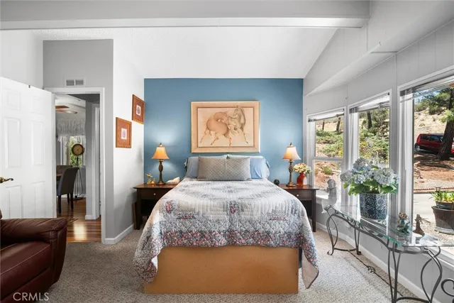 a bedroom with a bed and a flat tv screen on dresser