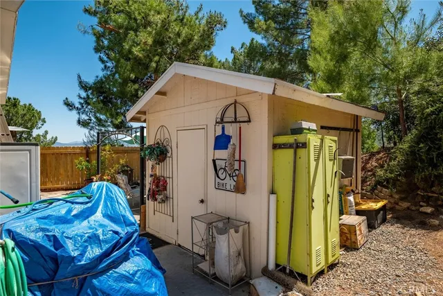 a view of a chair and table in the backyard with potted plants
