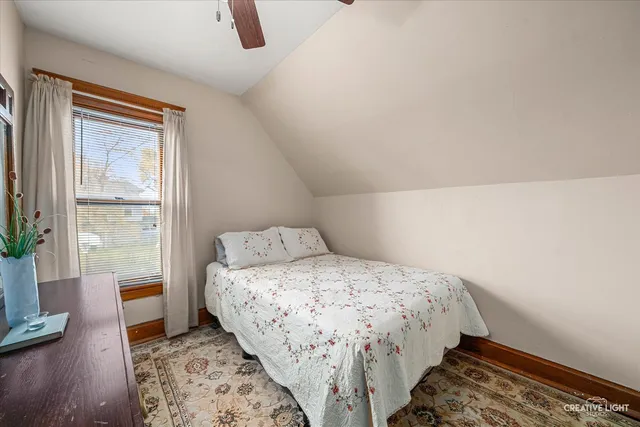 a bedroom with a bed and a lamp on the dresser