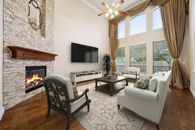 a living room with furniture a fireplace a flat screen tv and a large window