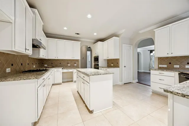 a large kitchen with stainless steel appliances cabinets a sink and a counter top space