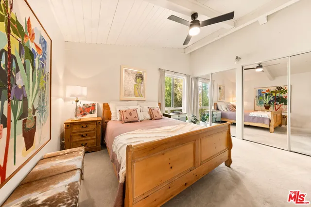 a large bedroom with a large bed and a chandelier