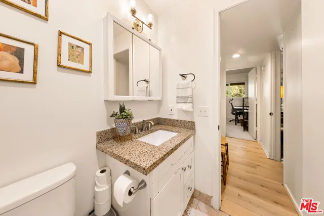 a bathroom with a granite countertop sink and a mirror