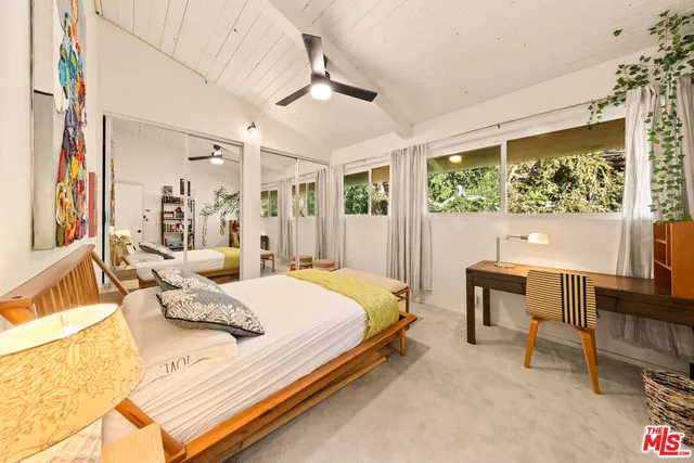 a bedroom with a bed and a large window