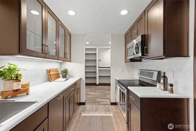 a kitchen with granite countertop a sink stainless steel appliances and cabinets