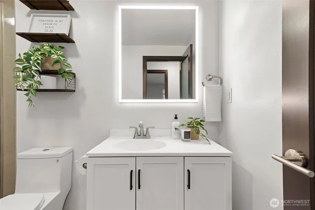 a bathroom with a sink toilet and mirror
