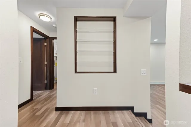 a view of a hallway with wooden floor and closet