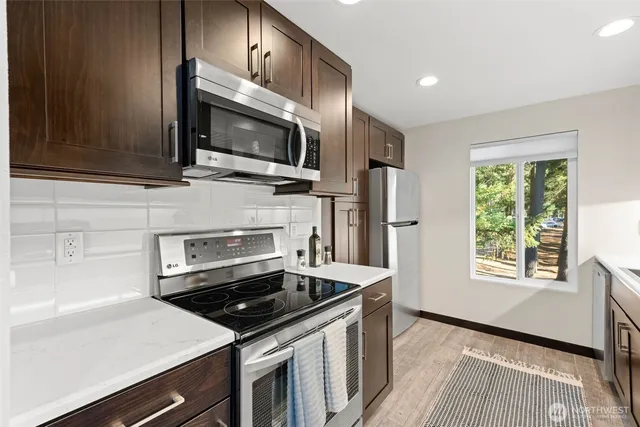 a kitchen with granite countertop a sink stove and refrigerator