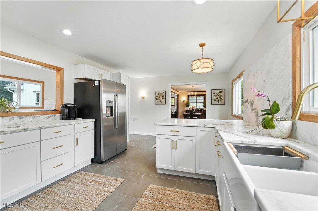 194 Ansel Road Geneva, OH 44041 - Photo 11 of 41 Kitchen with stainless steel fridge, white cabinetry, a peninsula, hanging light fixtures, and recessed lighting