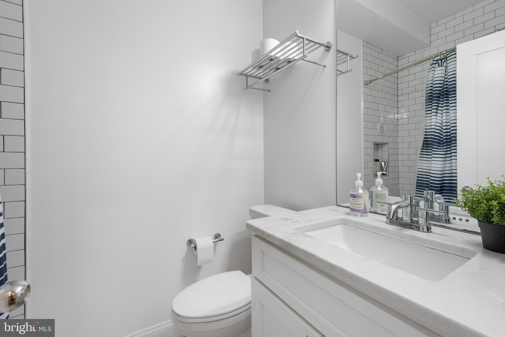 1428 Shepherd Street Northwest, Unit 1 Washington, DC 20011 - Photo 27 of 48 a bathroom with a granite countertop sink a toilet and shower
