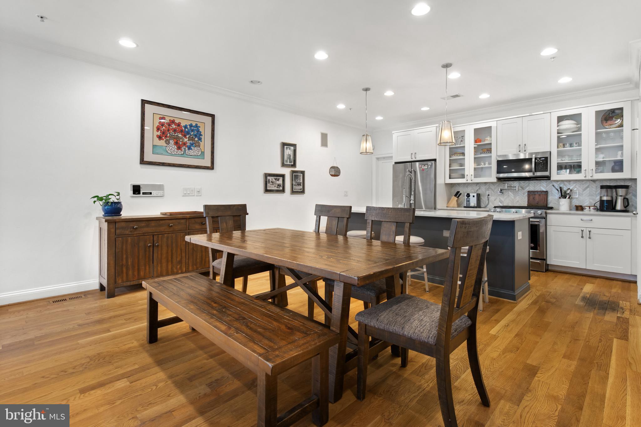 1428 Shepherd Street Northwest, Unit 1 Washington, DC 20011 - Photo 9 of 48 a dining hall with stainless steel appliances a dining table and chairs with wooden floor