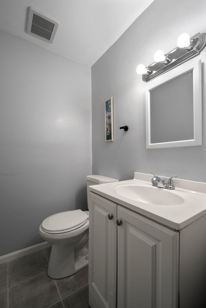 2102 West 73rd Street Chicago, IL 60636 - Photo 18 of 20 a bathroom with a granite countertop sink a toilet and a mirror