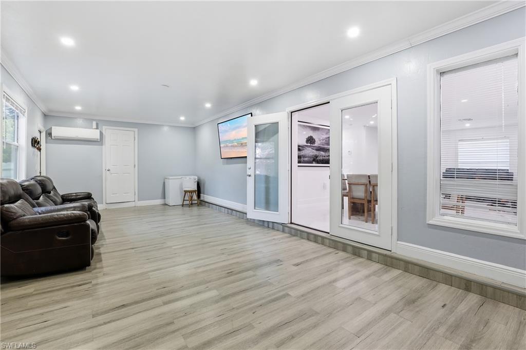 6005 Star Grass Lane Naples, FL 34116 - Photo 17 of 44 Living area with plenty of natural light, crown molding, light wood finished floors, and recessed lighting