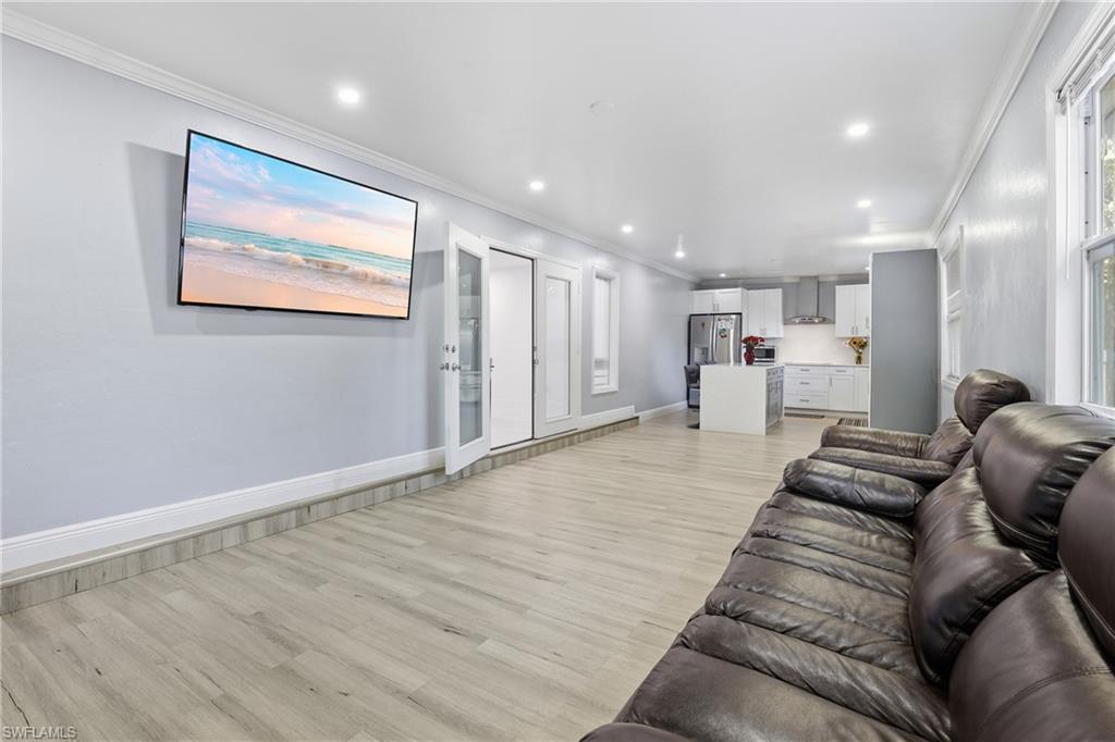 6005 Star Grass Lane Naples, FL 34116 - Photo 18 of 44 Living room with crown molding, light wood-style floors, and recessed lighting