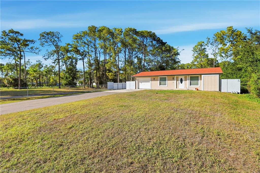 6005 Star Grass Lane Naples, FL 34116 - Photo 2 of 44 View of front of house with concrete driveway and an attached garage
