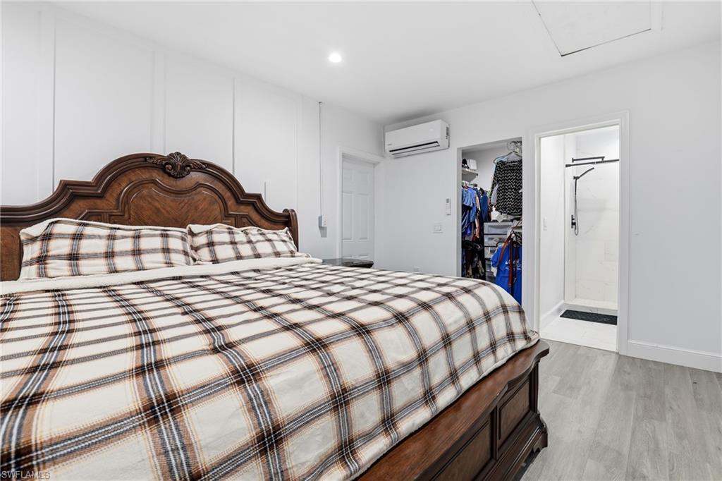 6005 Star Grass Lane Naples, FL 34116 - Photo 21 of 44 Bedroom featuring light wood-style floors, a spacious closet, ensuite bath, and recessed lighting