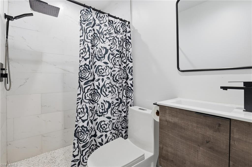 6005 Star Grass Lane Naples, FL 34116 - Photo 23 of 44 Bathroom featuring a tile shower and vanity