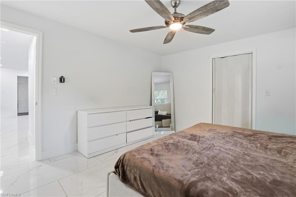 6005 Star Grass Lane Naples, FL 34116 - Photo 25 of 44 Bedroom featuring marble finish floors and a ceiling fan
