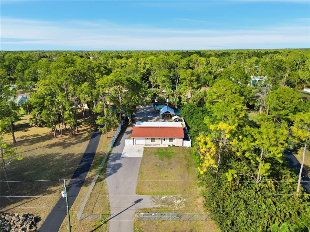 6005 Star Grass Lane Naples, FL 34116 - Photo 40 of 44 Aerial view of property and surrounding area featuring a heavily wooded area