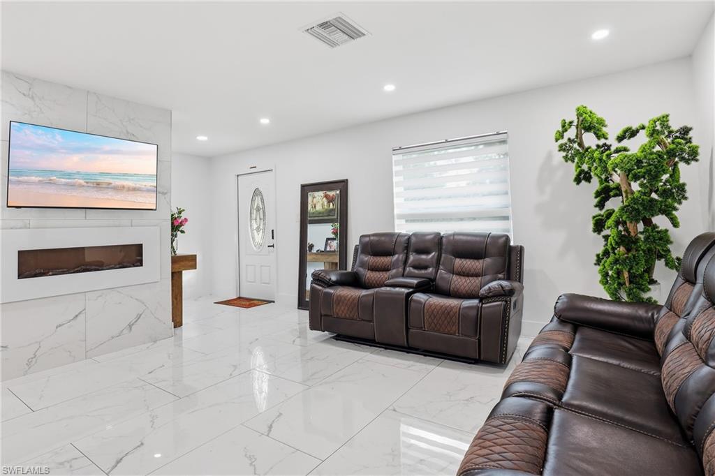 6005 Star Grass Lane Naples, FL 34116 - Photo 8 of 44 Living room with a premium fireplace, recessed lighting, and light marble finish flooring