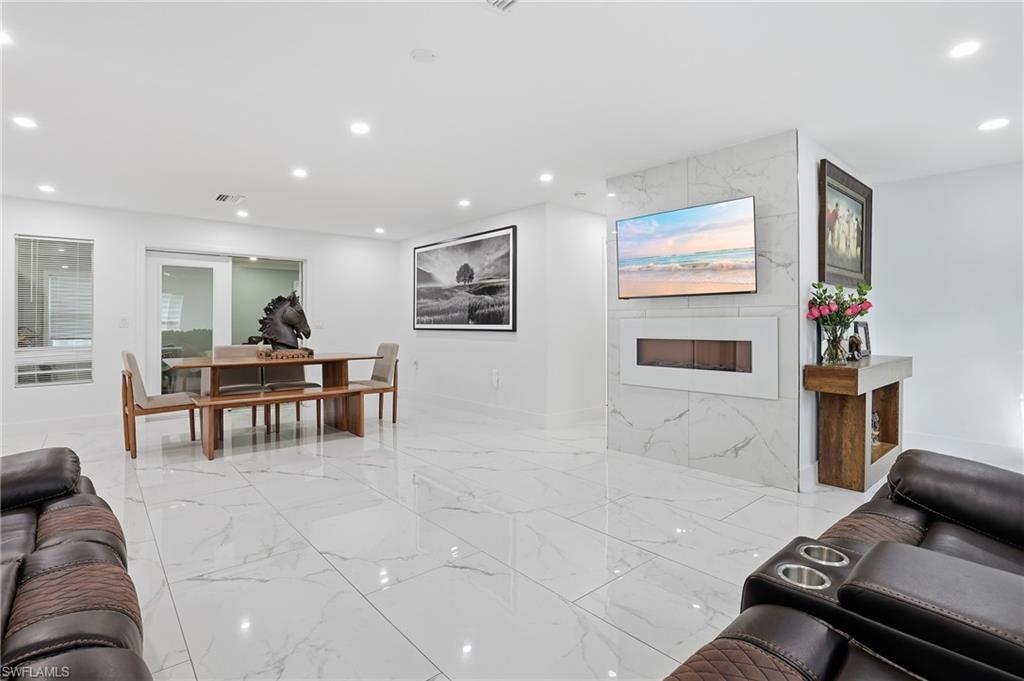 6005 Star Grass Lane Naples, FL 34116 - Photo 10 of 44 Living room with recessed lighting, a fireplace, and light marble finish flooring