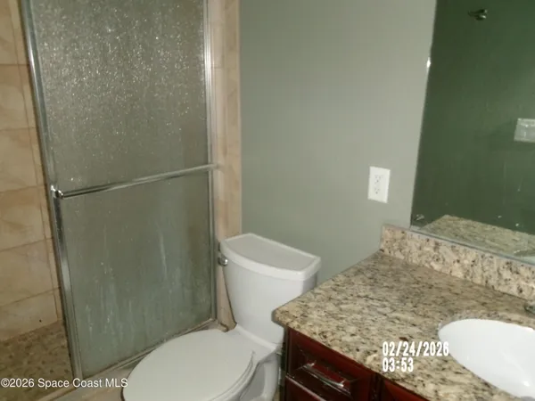 a bathroom with a granite countertop toilet and a sink