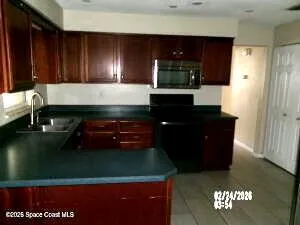 a kitchen with granite countertop a refrigerator a stove and a microwave oven