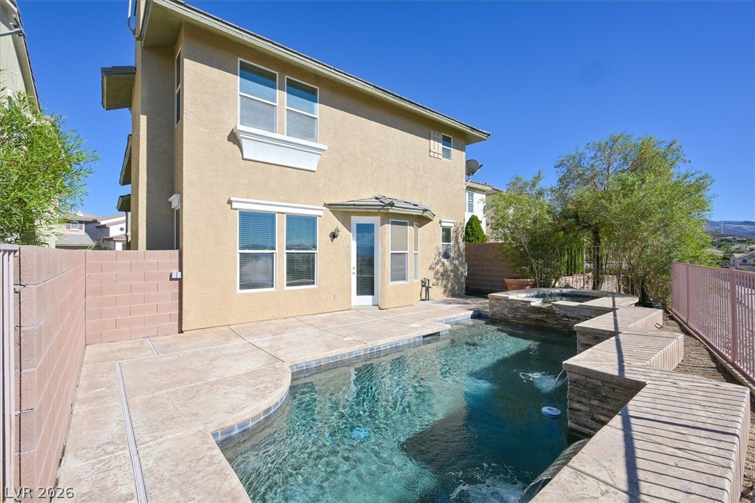 2447 Kaymin Ridge Road Henderson, NV 89052 - Photo 3 of 40 A sparkling swimming pool highlights this backyard oasis adjacent to the stucco exterior.