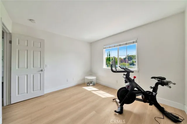 a spacious bedroom with a bed and wooden floor