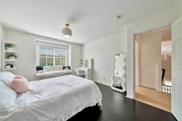 a view of a hallway with wooden floor closet and windows
