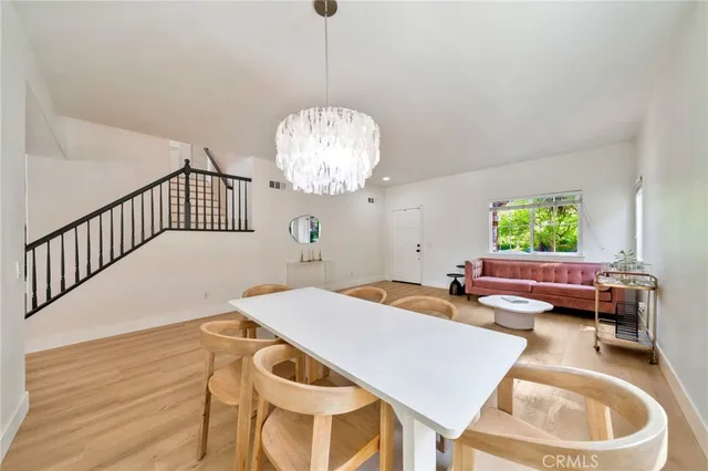 a dining room with furniture a chandelier and wooden floor