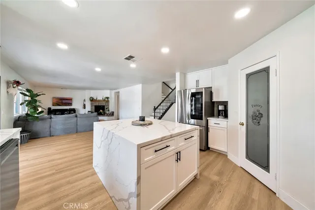 a large kitchen with stainless steel appliances a refrigerator and a stove top oven