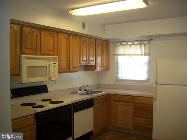 a kitchen with a stove cabinets and a window