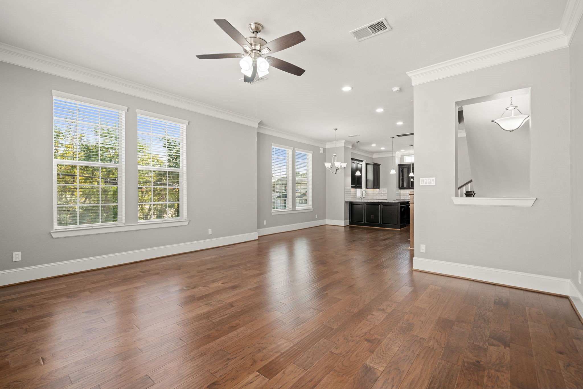 6703 Highclere Manor Lane Houston, TX 77055 - Photo 12 of 36 a view of an empty room with a kitchen and wooden floor