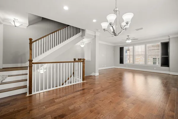 a view of a livingroom with wooden floor and stairs