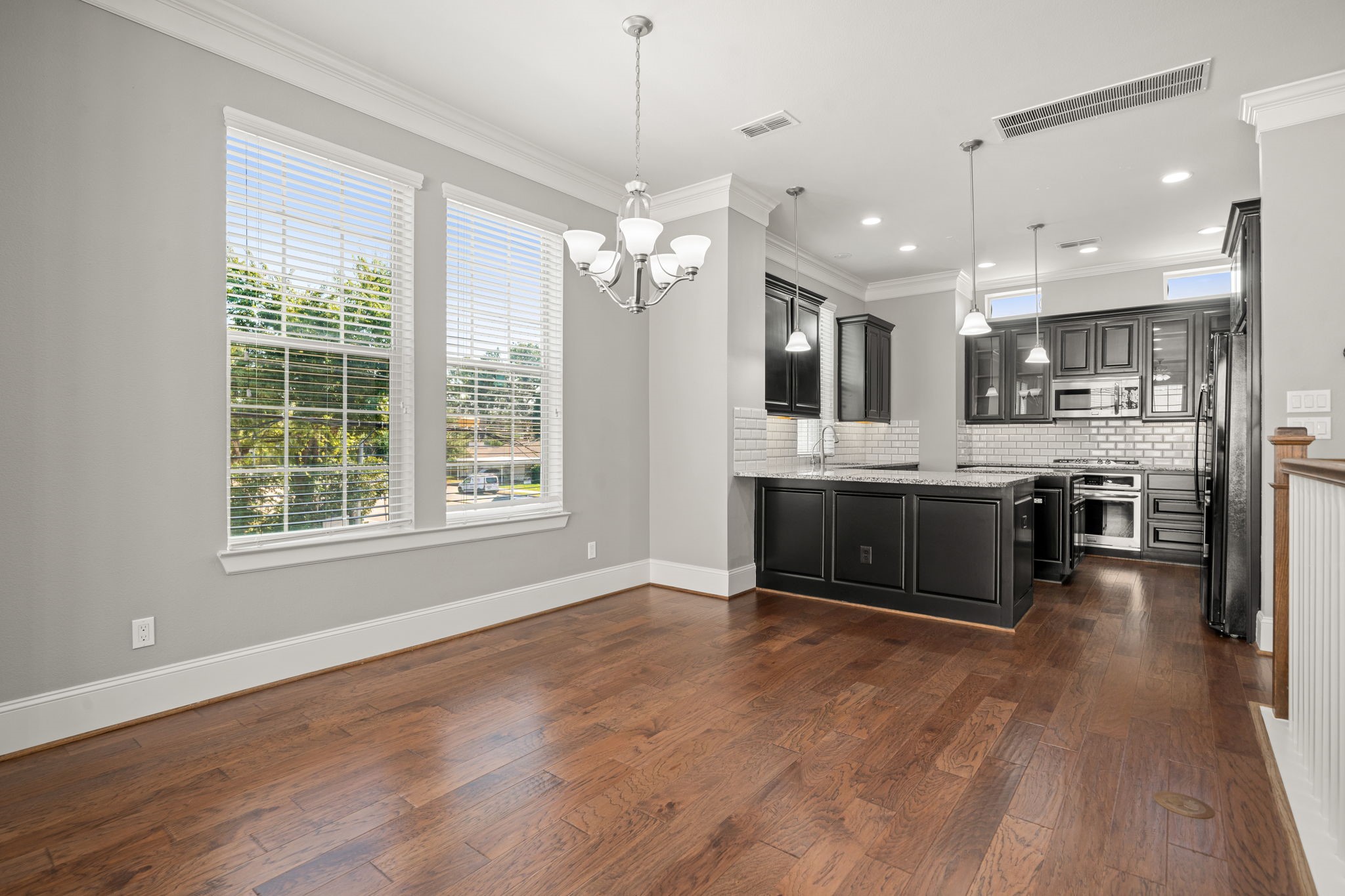 6703 Highclere Manor Lane Houston, TX 77055 - Photo 17 of 36 a large kitchen with kitchen island a large counter top space stainless steel appliances and a window