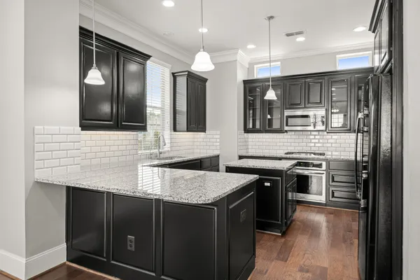 a kitchen with stainless steel appliances granite countertop a sink a stove and a refrigerator