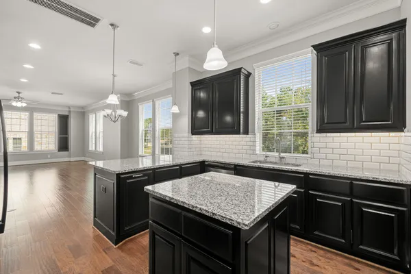 a kitchen with granite countertop cabinets stove top oven and microwave