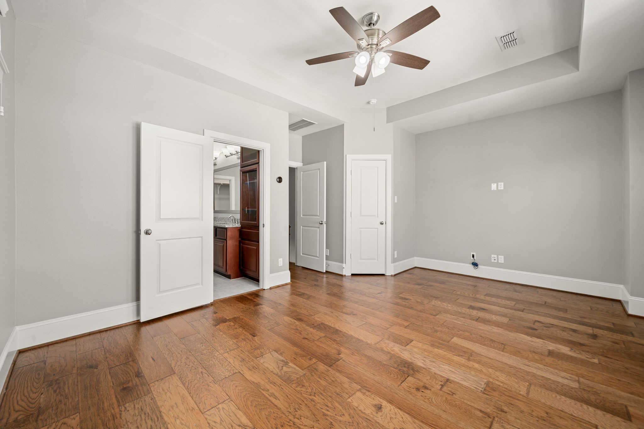 6703 Highclere Manor Lane Houston, TX 77055 - Photo 26 of 36 an empty room with wooden floor and ceiling fan
