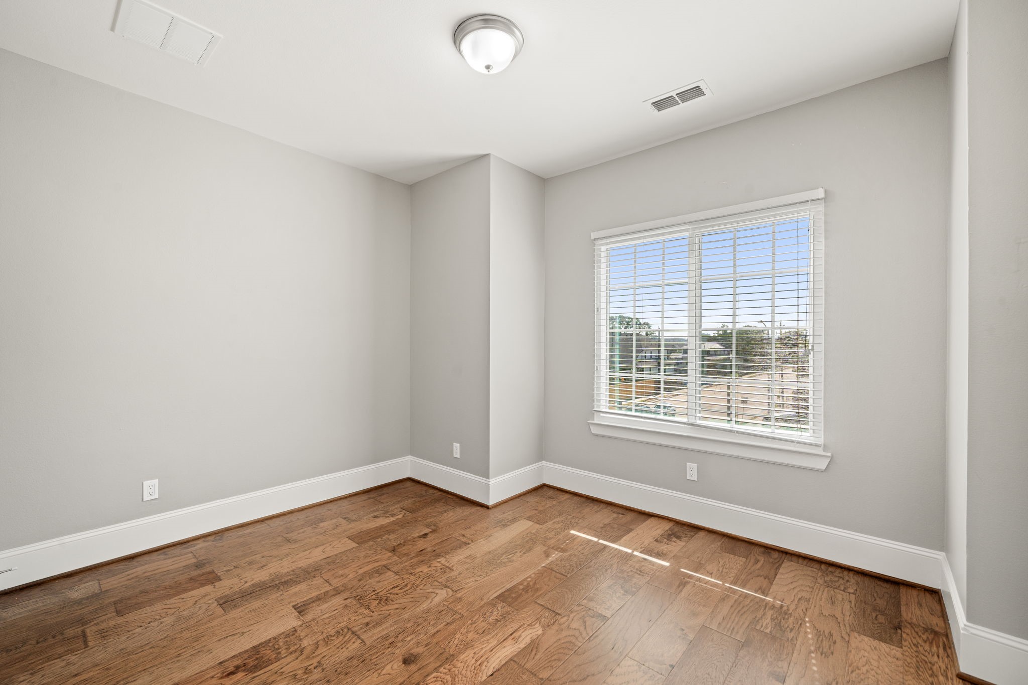 6703 Highclere Manor Lane Houston, TX 77055 - Photo 30 of 36 an empty room with wooden floor and windows
