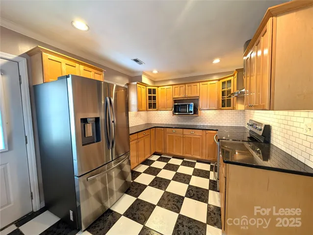 a kitchen with stainless steel appliances granite countertop a refrigerator and a sink