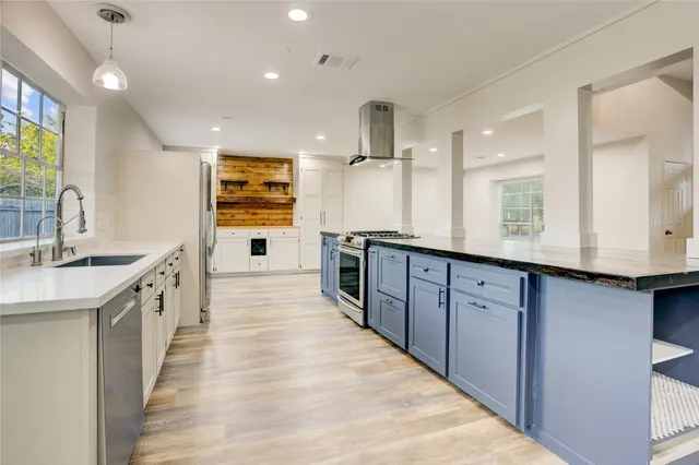 a large kitchen with stainless steel appliances kitchen island granite countertop a large counter top a sink stainless steel appliances and windows