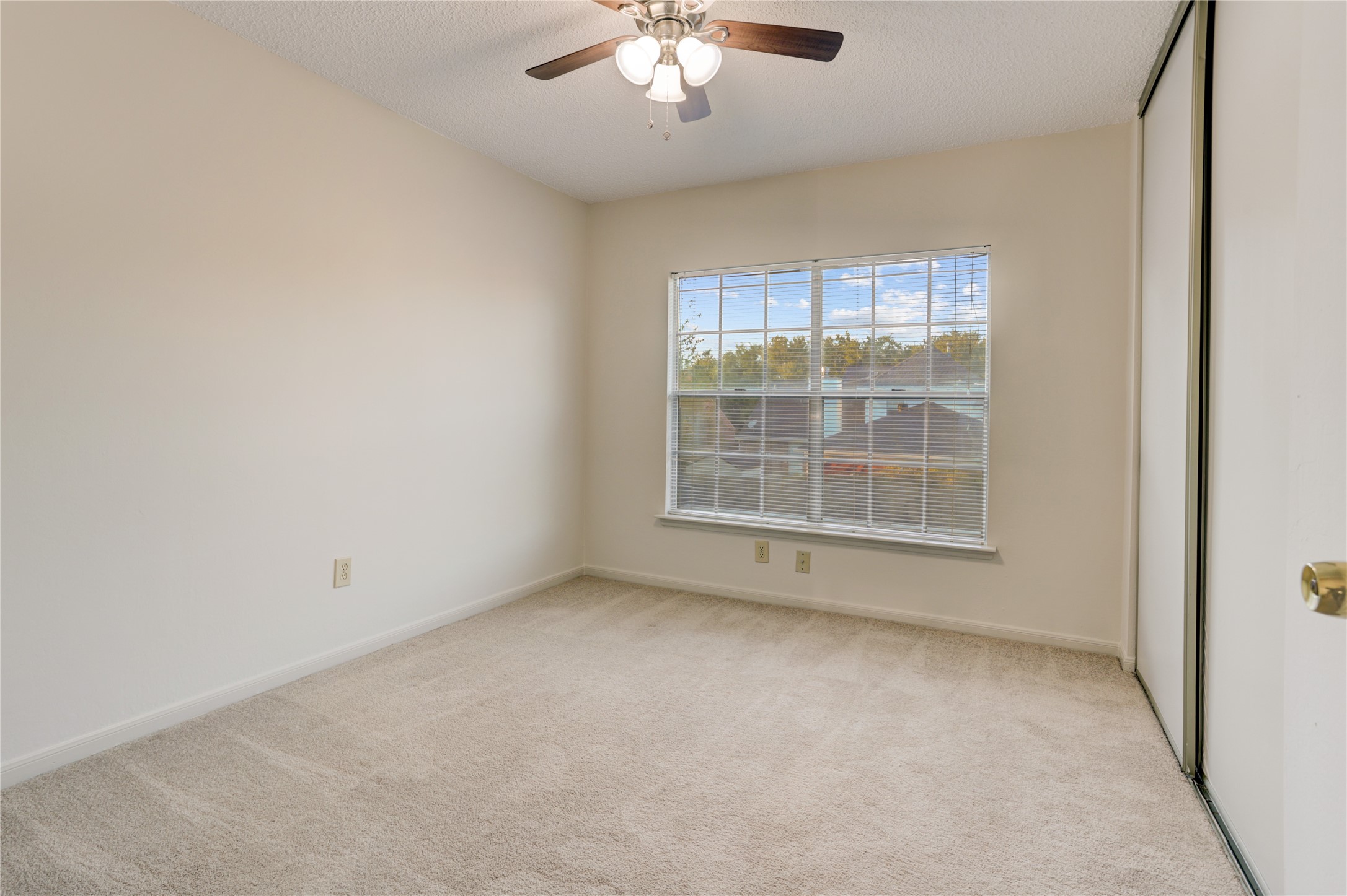 3122 Rimrock Drive Missouri City, TX 77459 - Photo 22 of 29 an empty room with a chandelier fan and windows