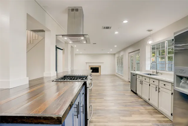 a kitchen with kitchen island a stove a sink and a refrigerator