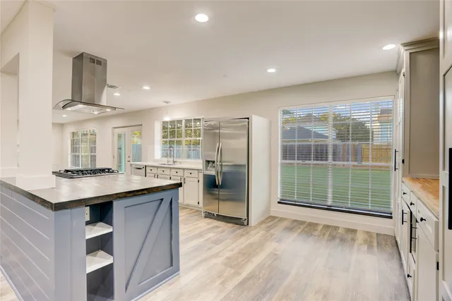 a kitchen with stainless steel appliances granite countertop a sink stove and refrigerator